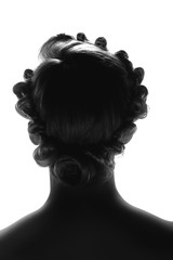 Silhouette of young woman posing on a white background. Back view