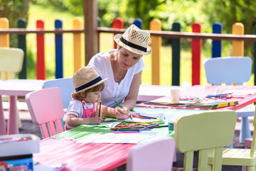mom and little daughter drawing a colorful pictures