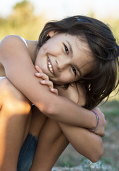 Little girl, squatting and smiling.