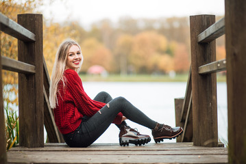 beautiful happy girl in a red sweater outdoors, woman is resting at sunset