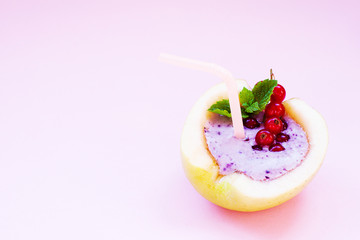 Smoothie in apple with blueberry, banana, mint, red currant and milk on pink background. Flat lay. Minimal and modern summer concept.