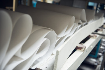 A beautiful smooth clean paper roll machine creating a continuous sheet of white freshly made paper...