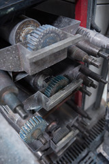 Beautiful metal industrial machinery steel cogs in a rustic industrial factory setting. Well used processing machinery parts.