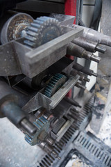 Beautiful metal industrial machinery steel cogs in a rustic industrial factory setting. Well used processing machinery parts.