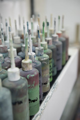 Industrial fabric and wallpaper dye ink paint, in plastic bottles with nozzles. Fabric dye is used in creating colour for the clothing and textile industry. fashion industry. Muted colours.
