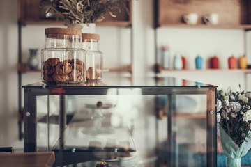 Laconic image of glass case with jars of cookies on it