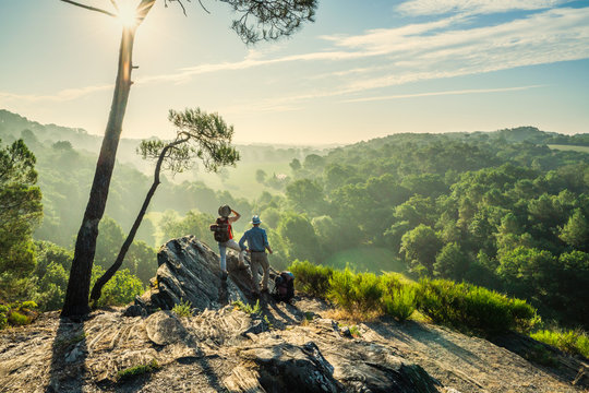 Hiker Couple Walk On A Mountain Trail, Overlooking The Valley.