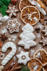 Christmas dekoration with spices and cookies in the shape of snowflakes, cinnamon sticks and star anise on dark brown paper background. Top view.