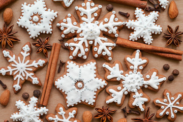 Christmas dekoration with spices and cookies in the shape of snowflakes, cinnamon sticks and star anise on dark brown paper background. Top view.
