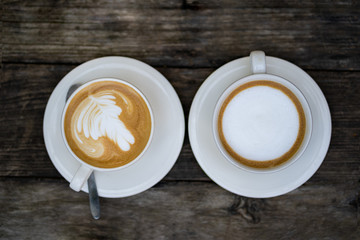 The top view on a cup of coffee on a wooden table