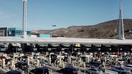 Drone video showing US military helicopters and cars lined up at San YsidroSan Diego California and Mexican Tijuana border