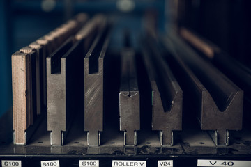 Vintage lead letterpress printing blocks against a weathered metal drawer background with bokeh.