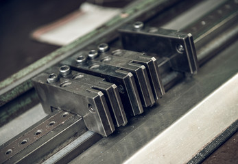 Vintage lead letterpress printing blocks against a weathered metal drawer background with bokeh.