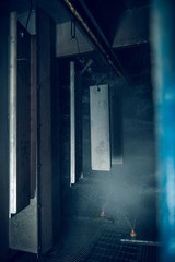 Fototapeta premium Industrial sheet metal steel products on a production line in an industrial factory setting, with atmospheric lighting. Being prepared for paint treatment. Industrial sheet metal.