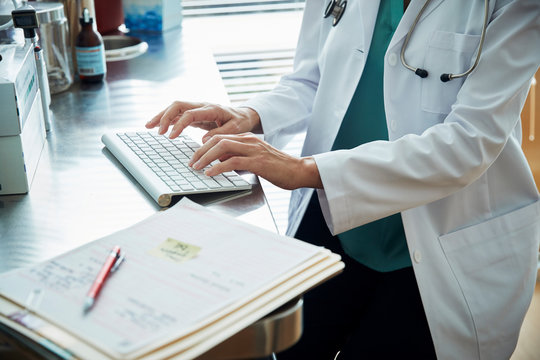 Doctor typing information on a keyboard