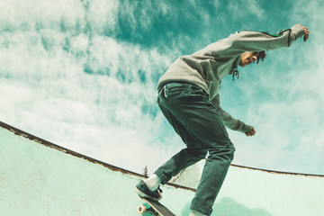 Guy skateboarder riding a skateboard on a skatepark. Young man jumping with a skateboard © Rafa