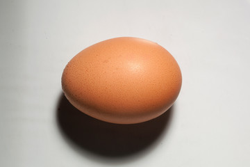 Brown chicken egg on a white background. Textures