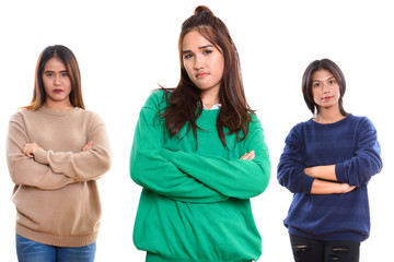 Studio shot of three young Asian woman friends with arms crossed