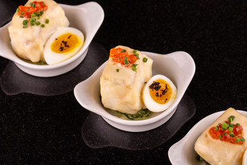 A Siberian salmon in sauce with quail egg, red caviar and greens