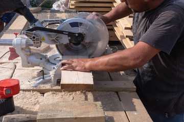 Man sawing a wood board with a circular saw