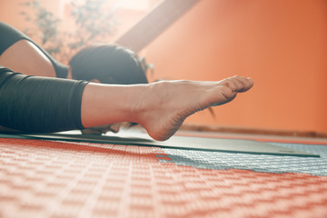 Sporty woman practicing yoga indoors. Kurmasana. Tortoise pose.
