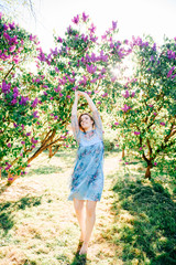 Young girl dancing in blooming garden on summer day