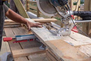 Man sawing a wood board with a circular saw