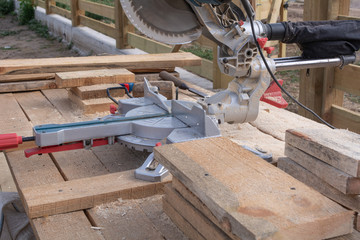 Electric saw and cut boards at a construction site