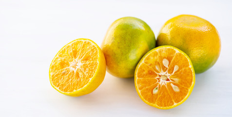 Green tangerine orange fruit on white table
