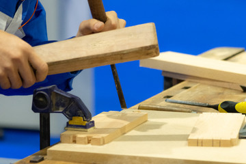 Carpenter with chisel and hammer in workshop