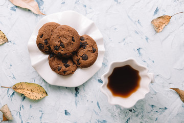 Autumn still life. Cookies and autumn leaves on white cement background