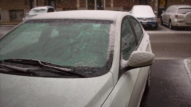 Timelapse of snow building up on a car during snowstorm