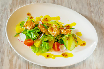 Salad on a white plate on a wooden table
