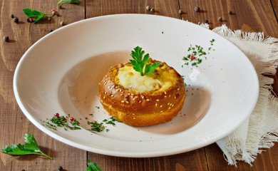 Baked vegetables, meat and cheese in a plate on the table