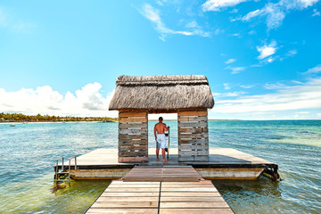 man with surfboard on jetty in mauritius island, belle mare beach