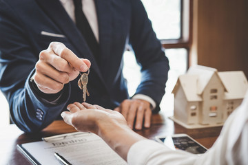 Real estate agent Sales manager holding filing keys to customer after signing rental lease contract of sale purchase agreement, concerning mortgage loan offer for and house insurance