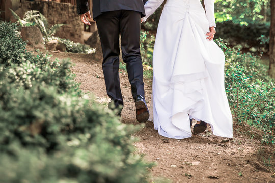 Image of Bride and groom legs walking away