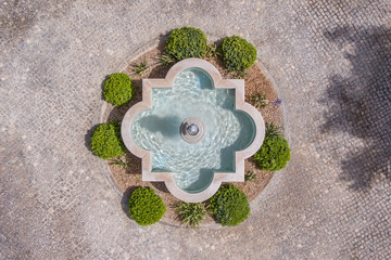 Fountain in the garden of cobblestones, shot from above from the sky, drone.