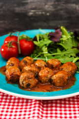 Meatball, bacon and potatoes with lettuce on white plat