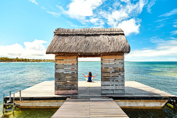 beautiful woman relaxing on jetty beside belle mare beach, mauritius island
