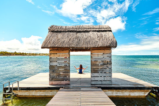beautiful woman relaxing on jetty beside belle mare beach, mauritius island