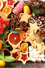 Christmas cookies, nuts and spices in wooden box on  background