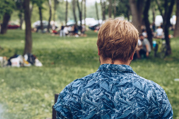 Rear view of man standing at a barbecue party outdoors