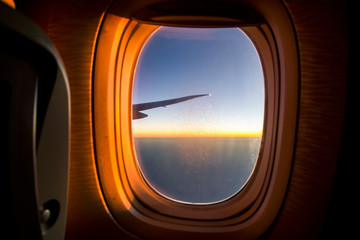 Airplane window during the flight sunset