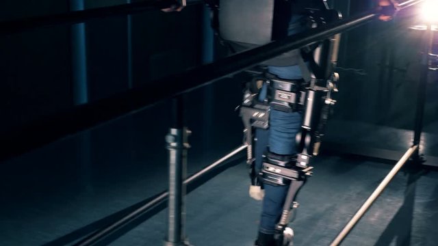 Handicapped patient walks, using prosthetic machine, close up.