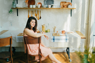 young French woman in sundress has Breakfast on her veranda
