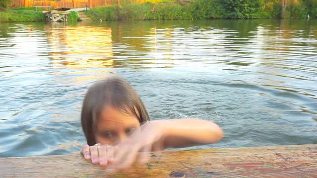 Little girl is swimming in a pond with an inflatable circle. 1920X1080 Full Hd.