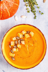 Pumpkin and carrot soup served with seeds.