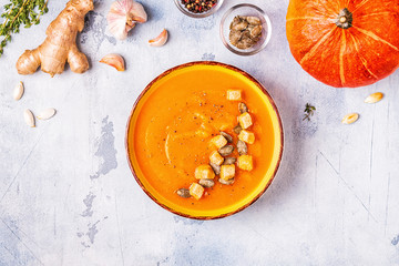 Pumpkin and carrot soup served with seeds.