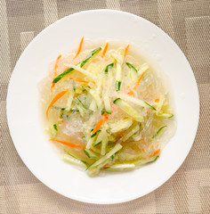 Chinese noodles with cucumber and carrot on a plate close-up